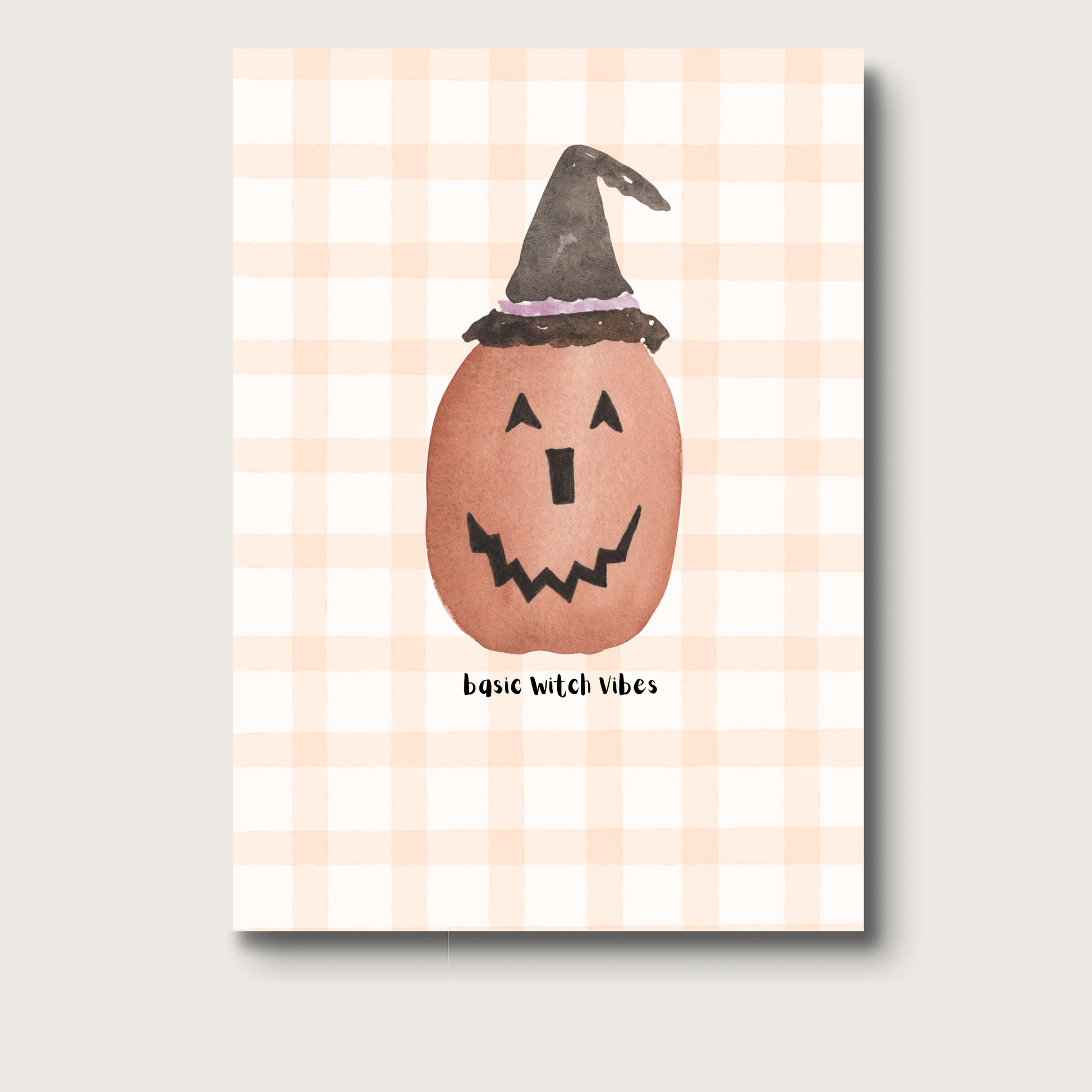 Notebook cover with a jack-o'-lantern wearing a witch hat on a gingham background. Underneath reads "basic witch vibes"