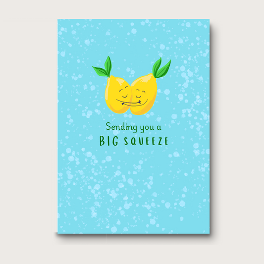Whimsical greeting card featuring digital art with two lemons, smiling with closed eyes, and hugging each other on a light blue background. The text below reads: Sending you a BIG SQUEEZE." A sweet and playful design for encouragement, friendship, or get well wishes. 