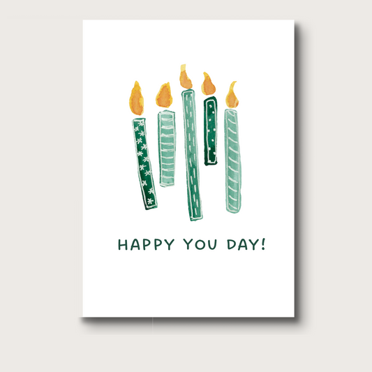 Birthday card featuring five green watercolor candles, each with a glowing flame. Below the candles, the text reads "Happy You Day!". A modern, minimal design perfect for birthdays of any age.