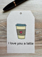 Gift Tag with a coffee cup illustration and 'I love you a latte' text placed on a wooden surface.