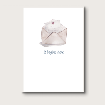 Card with an open envelope and a paper with a heart, featuring the text 'it begins here' on a white background.