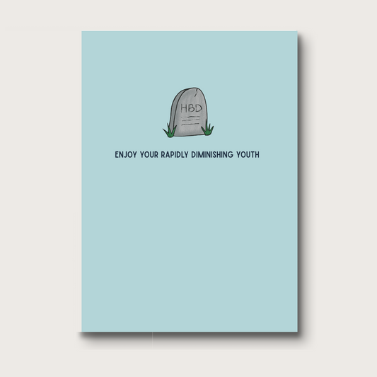 Digital illustration of a tombstone with 'HBD' engraved on it, set against a dusty blue background. The card reads "ENJOY YOUR RAPIDLY DIMINISHING YOUTH" in bold, sarcastic text. A humorous birthday card for someone who appreciates dark humor. 