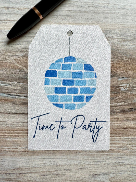 Gift Tag with a disco ball in shades of blue and the words "Time to Party" underneath, placed on a wooden surface.
