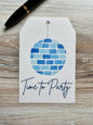 Gift Tag with a disco ball in shades of blue and the words "Time to Party" underneath, placed on a wooden surface.